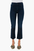 A person wears MOTHER dark blue cropped ankle jeans with a raw hem, paired with leopard print heels, highlighting the brand’s stylish denim fit.