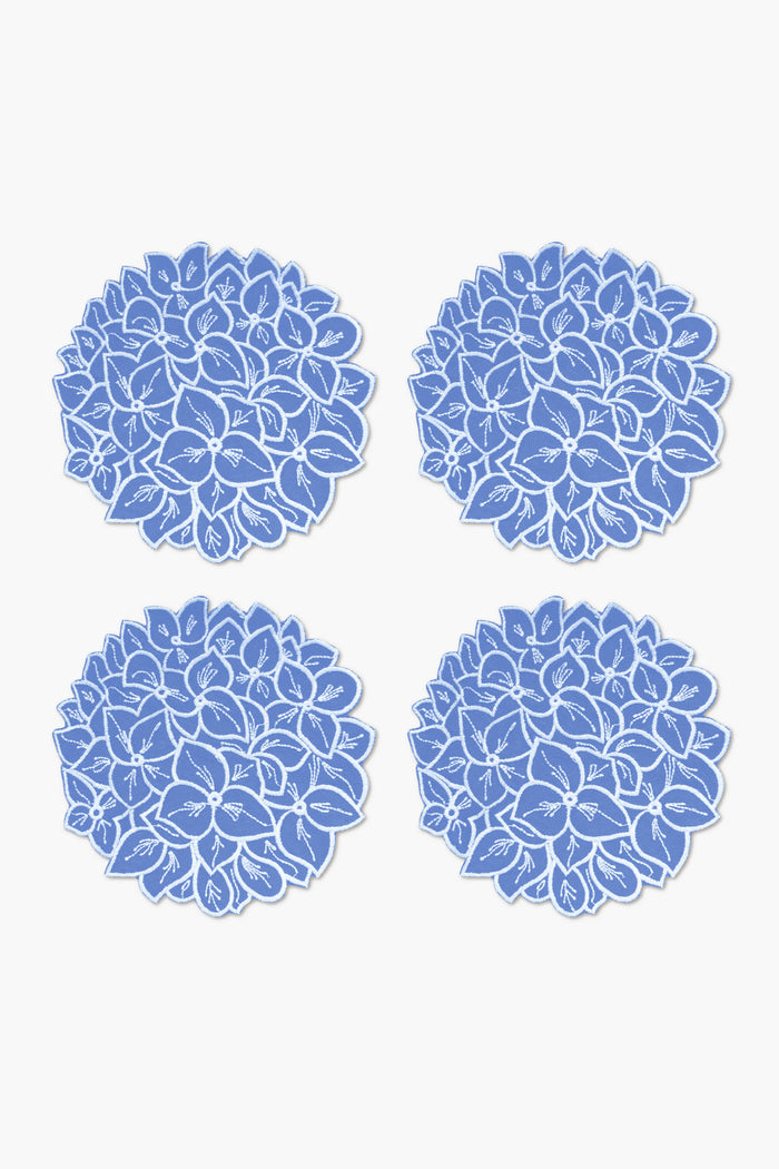Chefanie’s set of four round blue linen coasters features a white hydrangea floral design, arranged in a 2x2 grid—perfect for adding coastal charm to your table setting.
