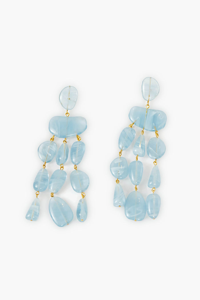 Cult Gaia Ice Blue Tallulah Earrings feature dangling, irregular-shaped light blue resin pebbles linked by small gold connectors, creating a striking statement accessory.