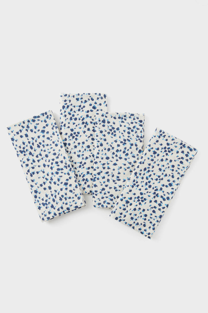 Three Tuckernuck Home rectangular cotton napkins with a blue floral print are arranged overlapping, making a perfect set of 4 stylish table napkins for your dining experience.