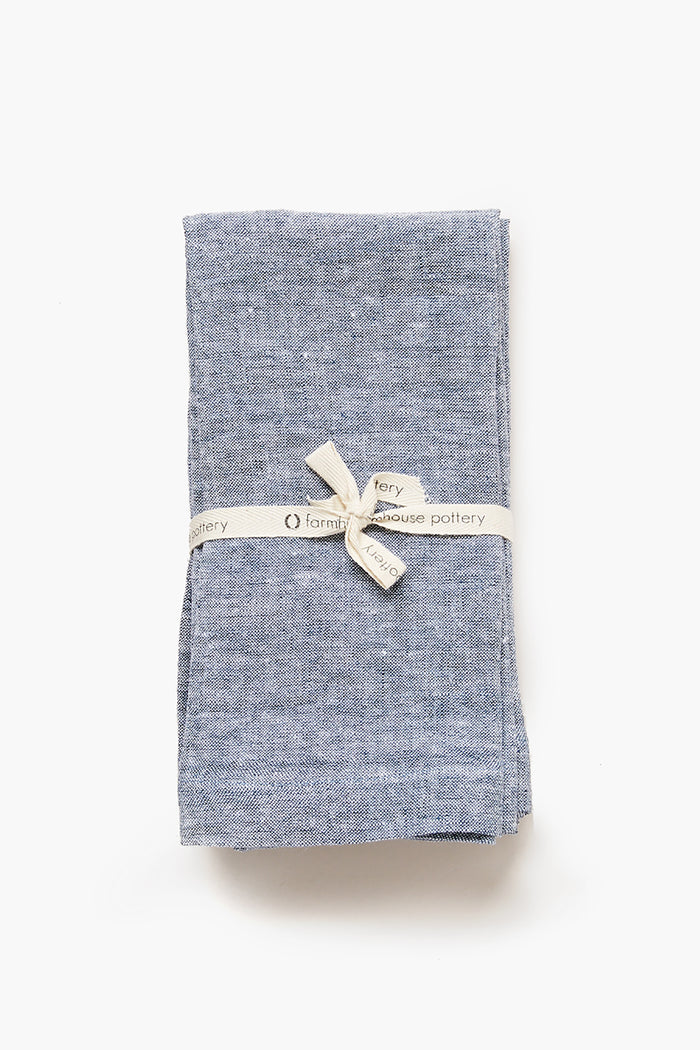 Indigo Washed Linen Napkins, folded and tied with a classic Farmhouse Pottery ribbon, offer an effortless, high-end touch for any meal. Set of four.