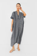 Woman wearing a loose-fitting, hand block printed black and white Love Tomas by Emerson Fry organic cotton caftan with short sleeves and beige sandals.