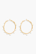 Mignonne Gavigan's Isla Pearl Hoops are gold-plated earrings accented with small, evenly spaced freshwater pearls around each hoop.