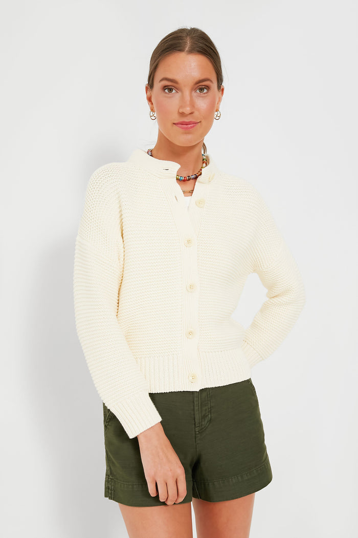 Woman wearing the Alex Mill Ivory Nico Chunky Cardigan, a cream button-up women's knitwear piece, paired with olive green shorts.