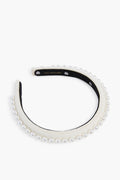 A Lele Sadoughi-inspired headband featuring a row of faux pearls, delicate floral accents, and a black inner lining.