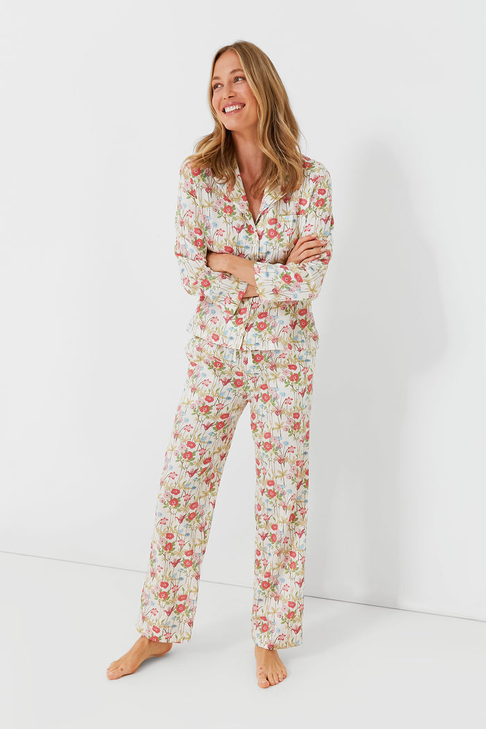 A woman stands barefoot, smiling to the side in Lalide a Paris’s matching floral cotton long-sleeve PJ set with pants, capturing the relaxed charm of French loungewear.