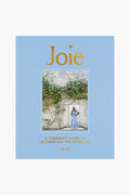 The cover of Joie, by Penguin Random House LLC, depicts a woman amid greenery; its subtitle is A Parisian’s Guide to Celebrating the French joie de vivre by Ajiri Aki.