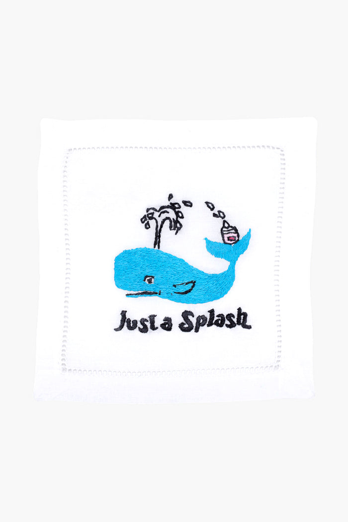 The August Morgan white cloth napkin features an embroidered blue whale, water spout, cocktail, and "Just a Splash" text—ideal as cocktail party decor or a charming hostess gift.