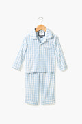 The Petite Plume Light Blue Gingham Pajama Set for children features a button-up long-sleeve top and matching pants in luxury cotton. Elegant family sleepwear, displayed neatly on a hanger.