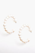 Tuckernuck Jewelry’s pearl hoop earrings feature round freshwater pearls in a semi-circle design. These hypoallergenic earrings provide timeless elegance and comfort for every occasion.