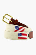 The Smathers and Branson beige canvas American flag needlepoint belt features brown full grain leather accents, a brass buckle, and hand-stitched needlepoint flags.