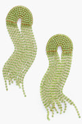 A pair of long, gold and green rhinestone Deepa Gurnani Warren earrings with a curved top and cascading wavy strands, inspired by Indian hand embroidery.