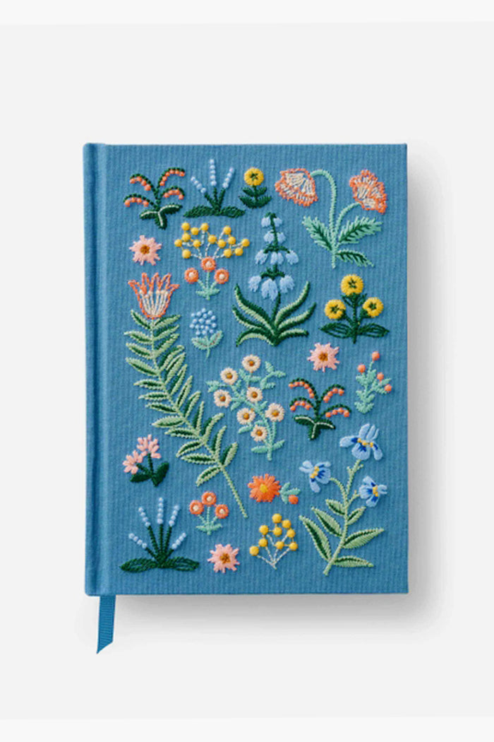 This blue hardcover journal by Rifle Paper Co. features embroidered vibrant floral designs and includes a matching blue ribbon bookmark.