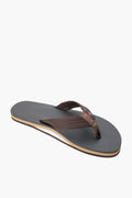 A single Rainbow Sandals flip-flop in brown has fabric straps, a thin layered base, and a textured sole made from recycled rubber.
