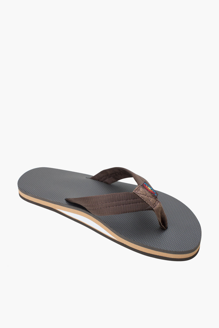 A single Rainbow Sandals flip-flop in brown has fabric straps, a thin layered base, and a textured sole made from recycled rubber.