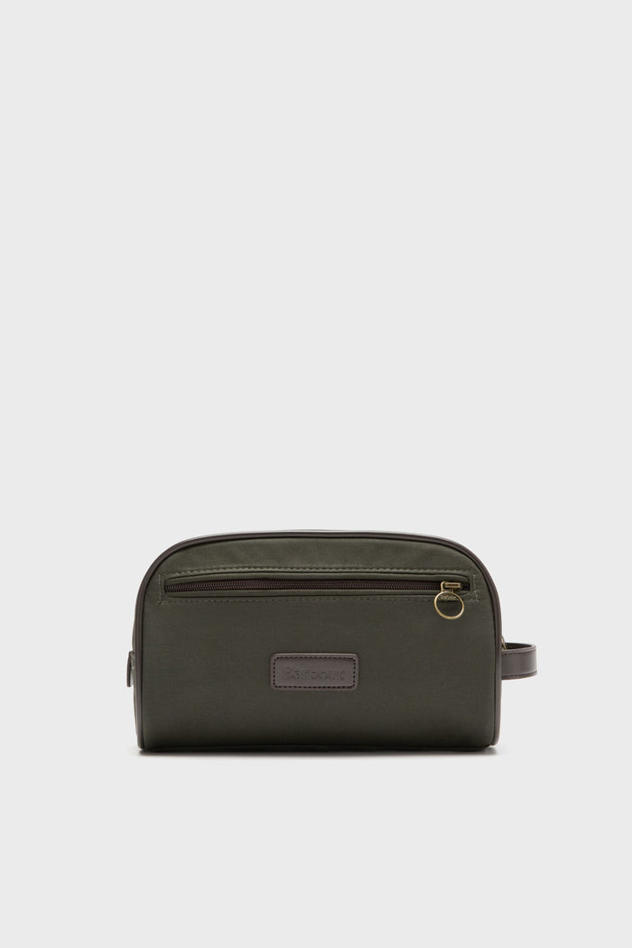 The Barbour Olive Wax Washbag is a rectangular, dark green men’s toiletry bag with a zippered front pocket, leather patch, gold zipper pull, and side handle.