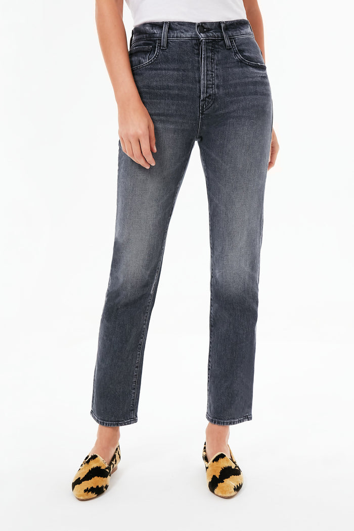 Person wearing high-waisted, straight-leg gray jeans from MOTHER, a white top, and yellow-and-black animal print flats.