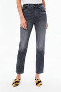 Person wearing high-waisted, straight-leg gray jeans from MOTHER, a white top, and yellow-and-black animal print flats.