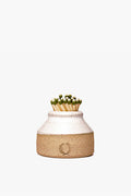 A Farmhouse Pottery, Inc ceramic milk bottle match striker holds green-tipped matches upright and showcases farmhouse style inspired by American stoneware.