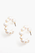 Tuckernuck Jewelry presents hypoallergenic gold hoops with round white pearls in a semi-circle design, secured with metal posts.