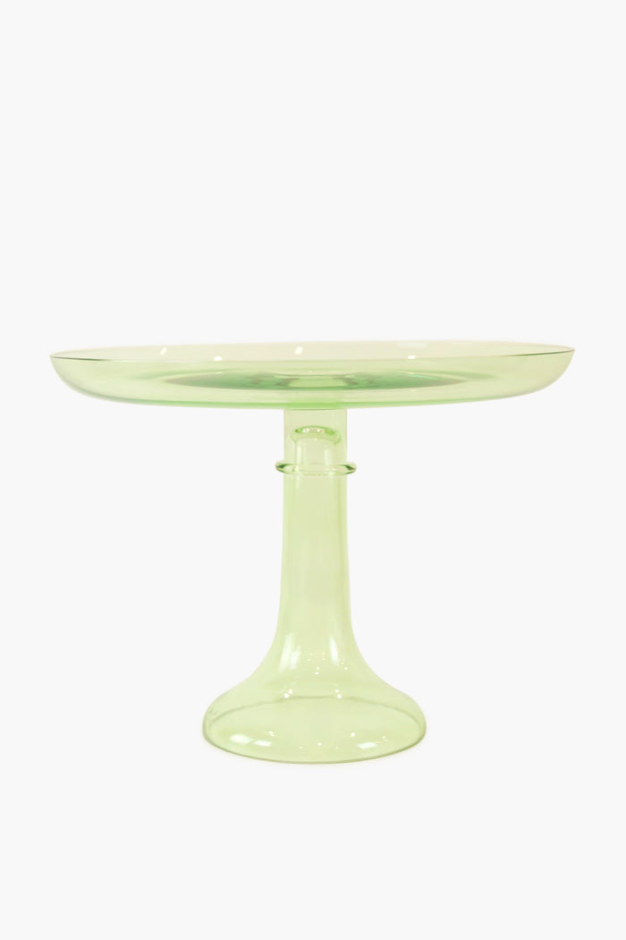 The Estelle Colored Glass cake stand, crafted from hand-blown translucent light green glass, features a wide flat top and sturdy pedestal base, lending your table a luxurious stemware-inspired look.