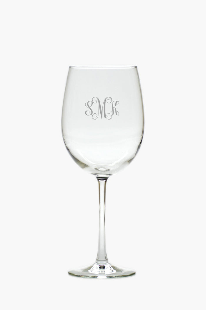 A clear tulip glass from Carved Solutions, engraved with the monogram SMK on its bowl, offers elegant personalized glassware.