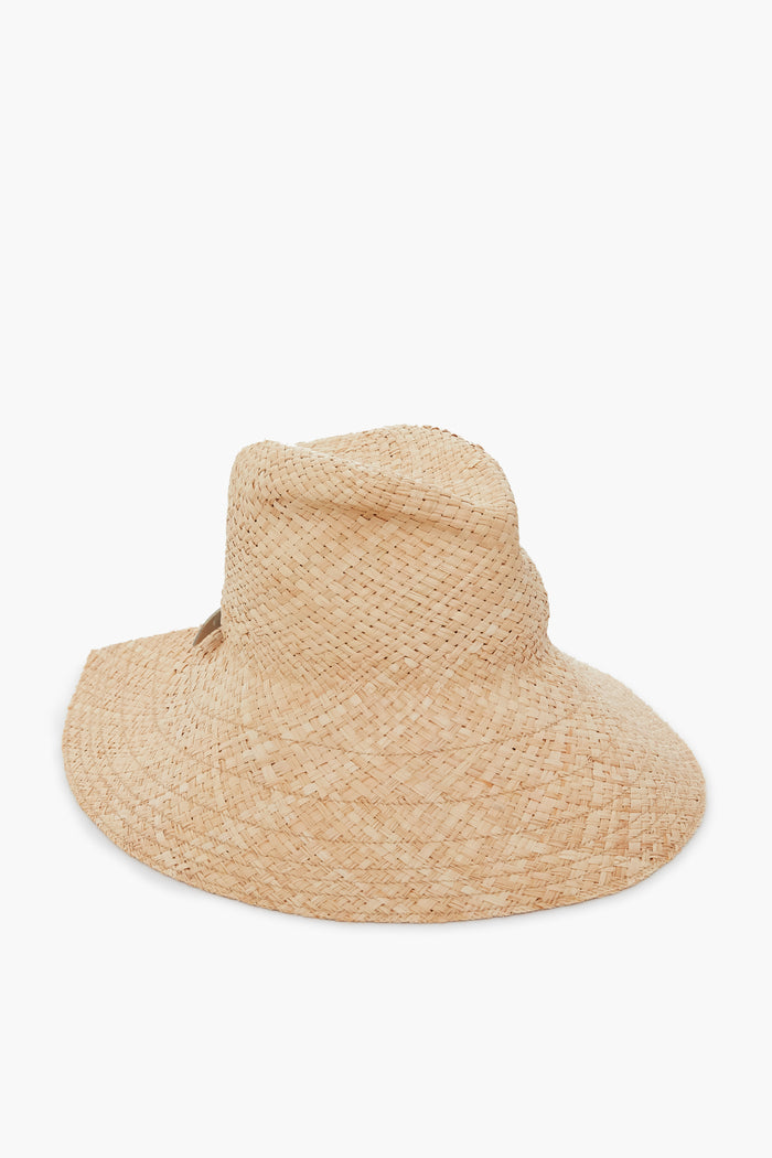The Lola Hats raffia sun hat features a wide brim, a slightly irregular crown, an adjustable leather tab, and a fedora-inspired style.
