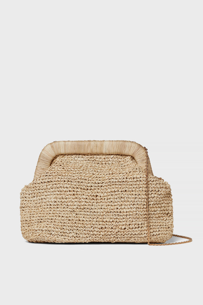 The Kayu rectangular hand-knitted raffia clutch is crafted from natural materials and features a structured frame, short handle detail, and a thin gold chain shoulder strap.
