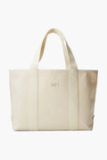 This medium beige canvas tote by Loeffler Randall features two handles and a front rectangular logo patch, offering classic style and everyday versatility.