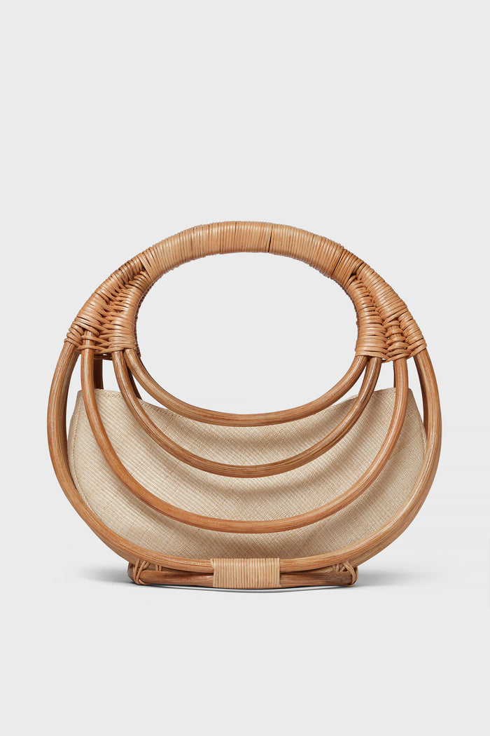 The Aranaz semi-circular handmade rattan bag features layered curved handles and a light fabric lining—an ideal choice for fans of artisanal accessories.