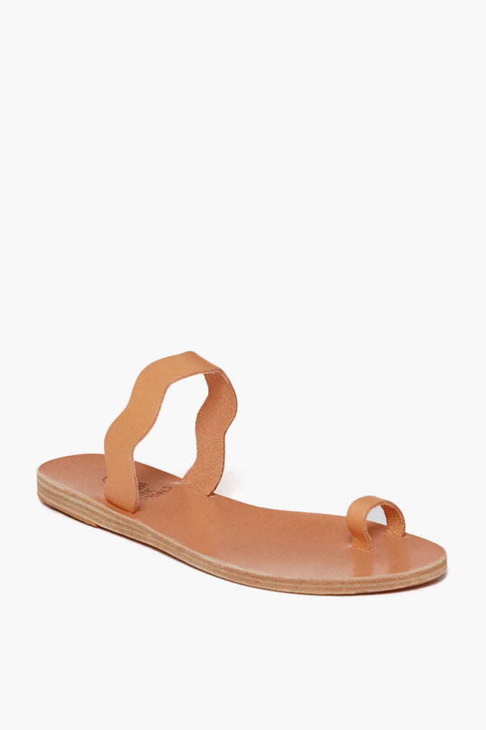A tan handmade flat sandal by Ancient Greek Sandals, featuring a toe loop and wavy midfoot strap, crafted from chemical-free leather.