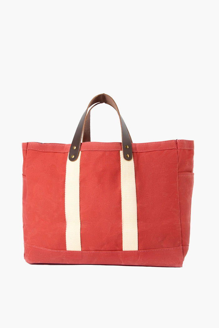 The CB Station nautical red tote features cream-colored straps and brown leather handles, crafted from durable waxed canvas for lasting style.