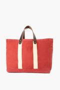 The CB Station nautical red tote features cream-colored straps and brown leather handles, crafted from durable waxed canvas for lasting style.