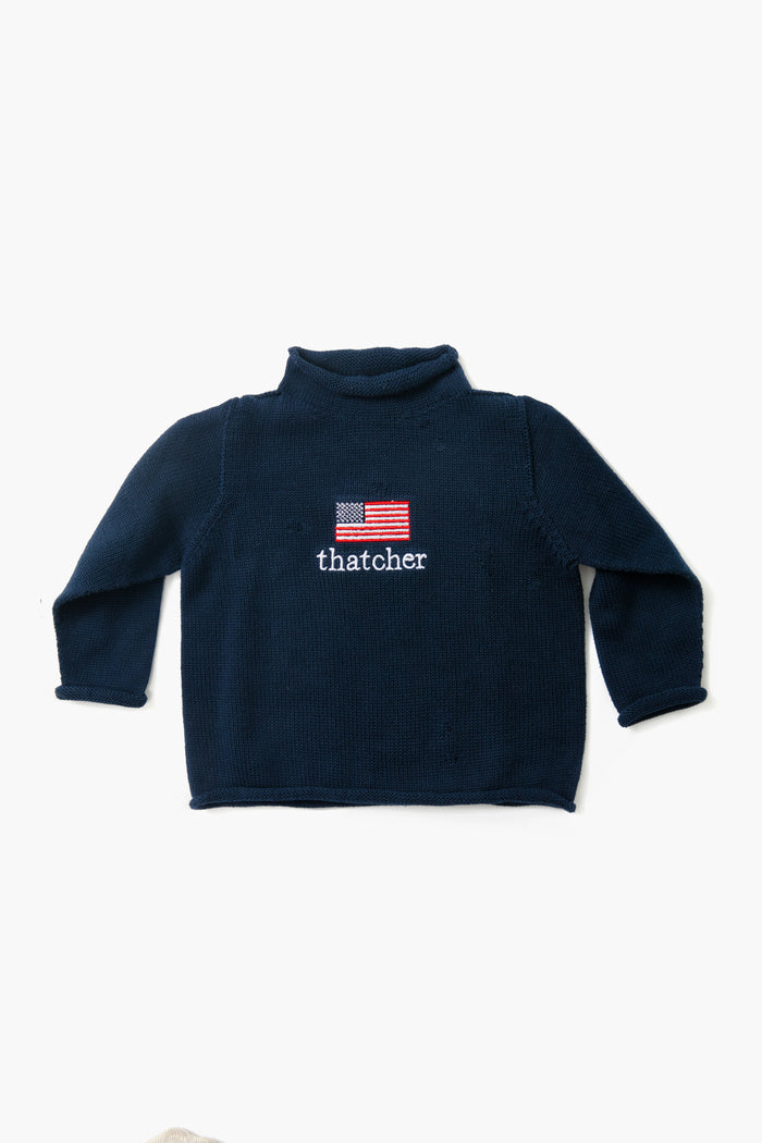 A Soft Idea navy blue long-sleeve cotton turtleneck sweater with "thatcher" and an embroidered American flag on the front. Made in USA. Machine washable.