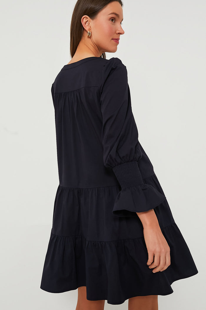 Model wearing the classic Navy Cotton Poplin Kenzo Dress, featuring an effortless, tiered design with smocked cuffs and an empire waist, embodying a fun, high-end style.