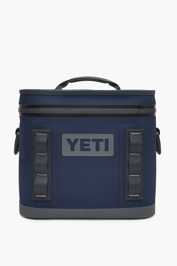 A navy blue YETI Hopper Flip cooler featuring a waterproof zipper top, side handles, and the YETI logo on the front.