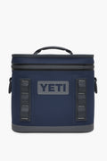 A navy blue YETI Hopper Flip cooler featuring a waterproof zipper top, side handles, and the YETI logo on the front.