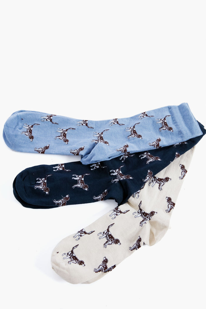 Three pairs of Barbour socks in blue, black, and cream feature a repeated dog pattern. Made from a soft cotton blend for comfort—ideal as a dog lover gift.