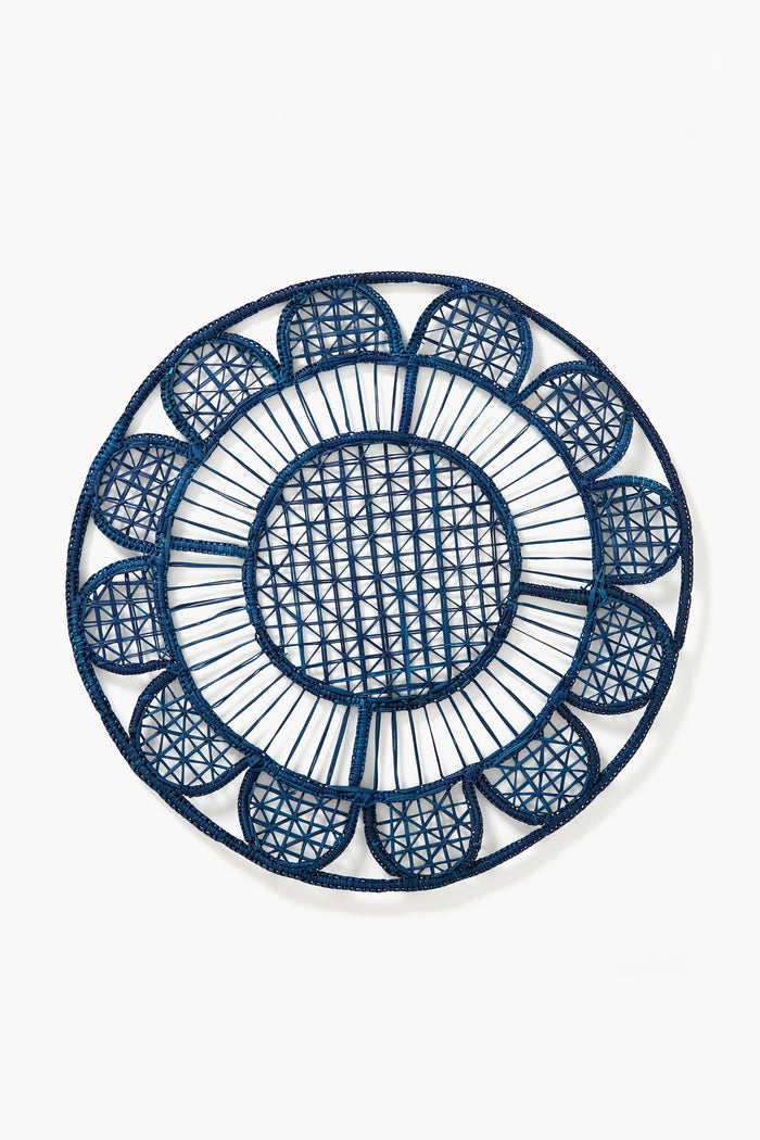The Coro Cora round handmade placemat, in navy blue with a geometric and scalloped edge design, is crafted from natural fibers to add artisan style to your table.