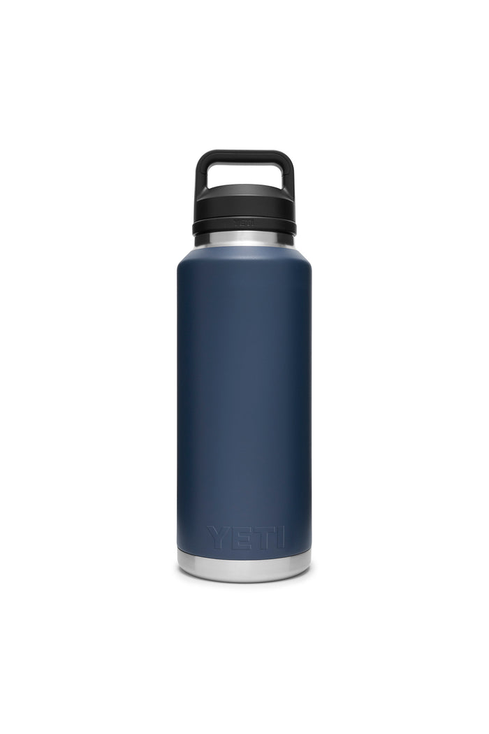 A YETI Rambler Bottle in matte dark blue with double-wall vacuum insulation and a black screw-on lid with handle, shown standing upright.