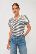 A woman stands confidently in a Pomander Place loose-fit crewneck top with black and navy stripes, puff short sleeves, and blue jeans.