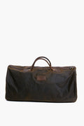The Barbour large dark brown waxed cotton duffel features two handles and a zippered top, making it perfect as an overnight bag.