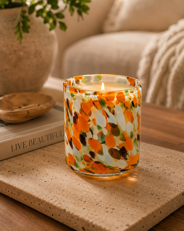 Decorative candle with floral pattern on a wooden surface