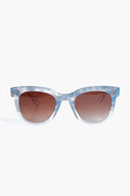 KREWE du optic’s Jena Sunglasses showcase blue and white marbled, handcrafted frames paired with brown gradient lenses that offer UVA/UVB protection.