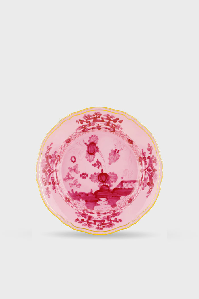 Handcrafted by Ginori 1735, this pink porcelain plate features a gold-trimmed edge and intricate floral and landscape motifs in deeper pink tones, inspired by the Oriente Italiano Porpora Salad Plate—an elegant addition to your table.
