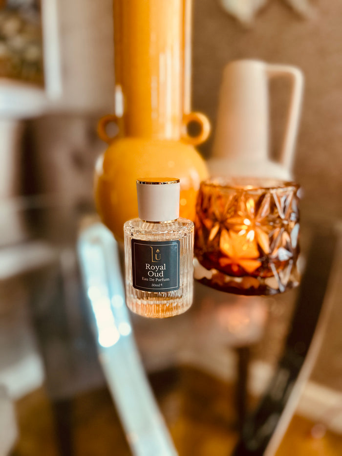 Oud & Bergamot Eau de Parfum by LU Fragrances — 50ml glass bottle with dark teal label, styled beside an amber candle holder
