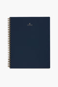 A navy blue spiral-bound APPOINTED Blue Lined Notebook with gold wire binding, a book-cloth cover, and a small gold logo and centered text on the front.