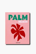 A pink Assouline book cover features "PALM BEACH" in green and white text, a bold red flower graphic, and the brand name Assouline at the bottom.