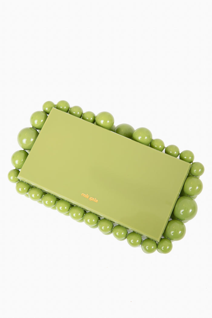 The Cult Gaia evening bag is a rectangular green acrylic box clutch, adorned with glossy round beads outlining the edges.