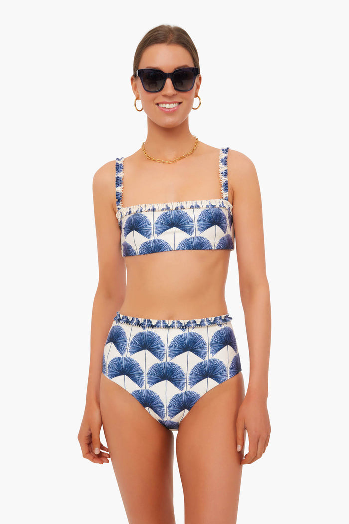 A woman models a stylish handmade bikini by AGUA BY AGUA BENDITA, crafted by Colombian artisans from recycled materials.